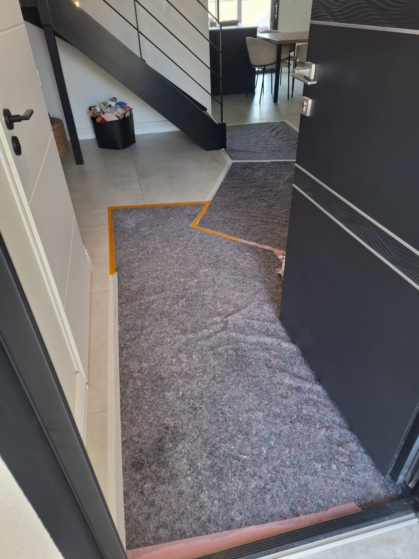 Entrée et couloir protégés par des bâches pendant les travaux de rénovation